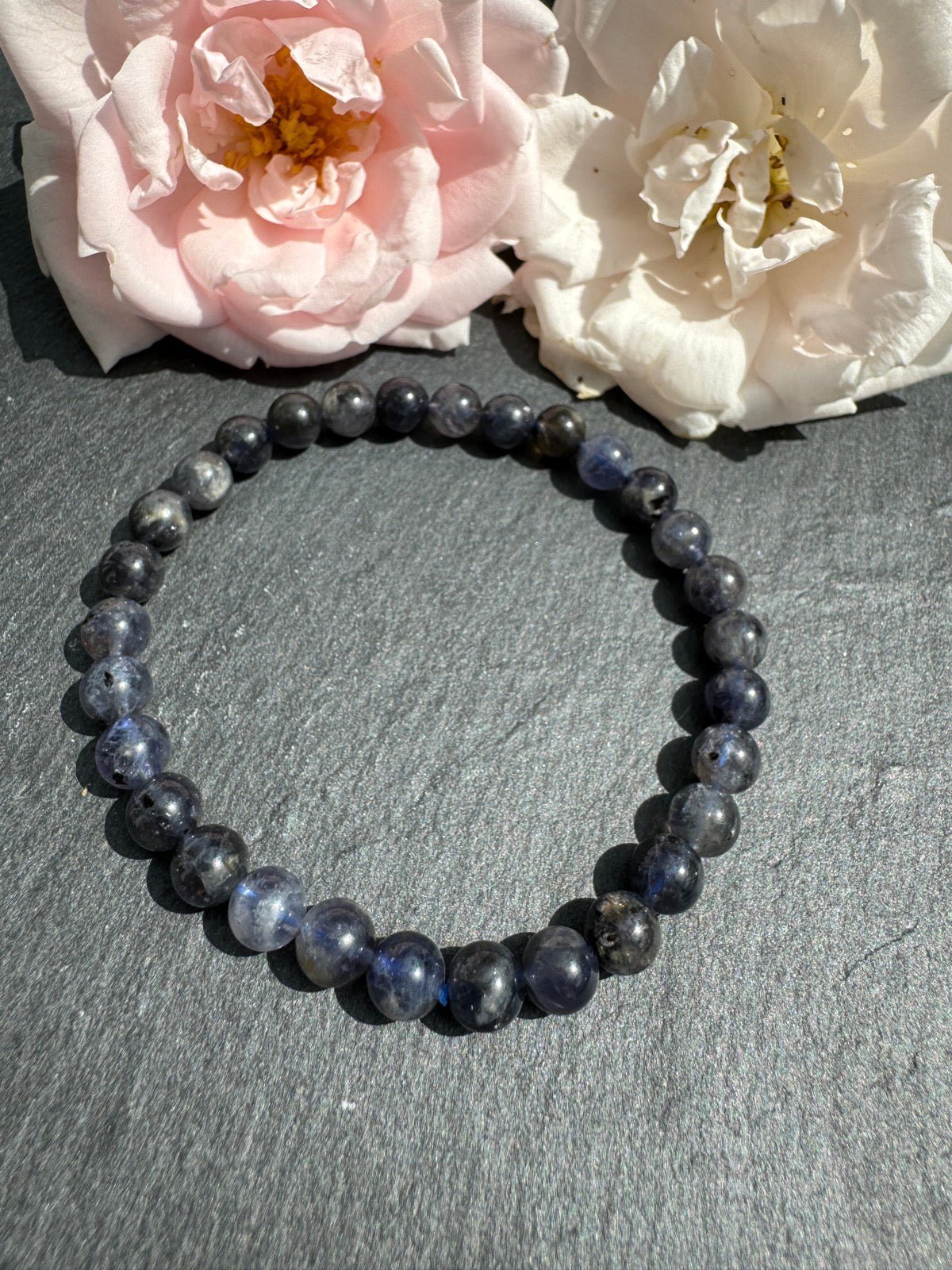 IOLITH Armband mit 6 mm Perlen - Perlenarmband auf einer Schieferplatte mit Rosenblüten als Deko