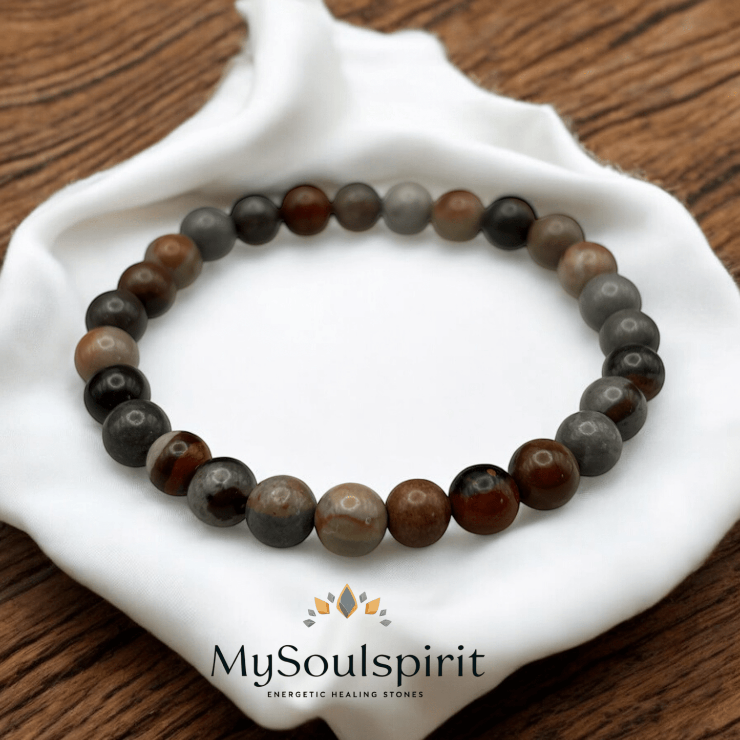 Polychrom Jaspis Perlenarmband mit 6 mm Perlen auf weißem Tuch.